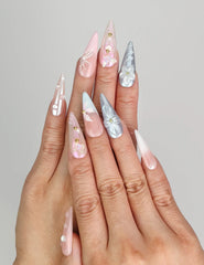 Model wearing Naillover Butterfly's Dream handmade press on nails Singapore with pastel floral details and gold bead accents.