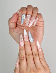 Close-up of Naillover Butterfly's Dream 3D summer nails in soft pastel tones with shimmering gold accents.