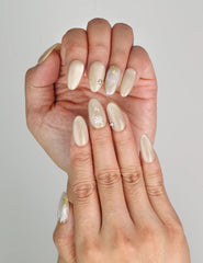 Close-up of Naillover Cappuccino Daisy trendy nails showing neutral beige tones and detailed floral art.
