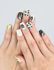 Model wearing Naillover Chic Contrast floral nails, showing dried flowers and gold foil accents.