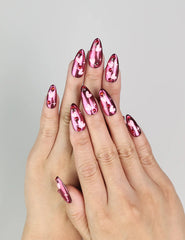 Model wearing Cupid's Curve handmade Singapore press on nails with magenta base, heart patterns, and rhinestone details