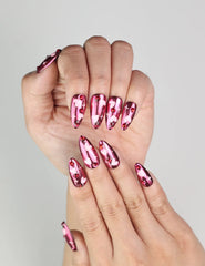 Close-up of Cupid's Curve Singapore press on nails by Naillover showing heart designs and sparkling rhinestone accents