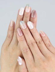 Model wearing Dusk Butterfly short oval nails with soft tones and floral shimmer by Naillover.