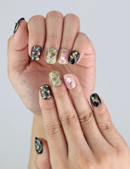 Close-up of Gem Enchant handmade press on nails by Naillover, showing black base with gemstone and star embellishments.