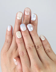 Model hand wearing Naillover Gentle Echo press on nails, featuring soft pastel tones and floral detail.