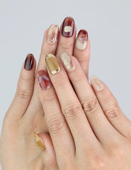 Wearing Naillover Gilded Brown press on nails with burgundy floral layers and golden gradients.