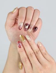 Close-up of Naillover handmade press on nails in Gilded Brown—earthy tones with floral detail and golden shimmer.