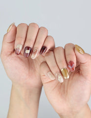Model hand showcasing Naillover Gilded Brown Singapore press on nails—romantic florals and glowing gradients.