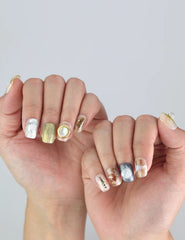 Close-up of Naillover Gold Leaf Whisper nails—floral accents, gold stripes, and 3D pearl for a trendy, classic finish.