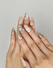 Naillover Golden Brown Floral Shine handmade press on nails styled on hand with matte and shimmering gold tones.