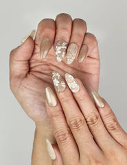 Elegant Naillover Golden Brown Floral Shine Singapore press on nails on hand, featuring delicate white floral designs.
