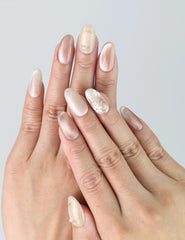 Model wearing Lunar Petal press on nails with soft pink gradient and floral accents, captured in natural light.