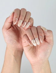 Side angle of hands showing the subtle shimmer and delicate flower detail on Naillover’s Lunar Petal nails.