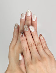 Model wearing Naillover Marble Blossom Singapore press on nails with marble design and golden accents.