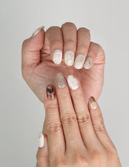 Close-up of Naillover Marble Blossom handmade press on nails in creamy white and earthy brown tones.