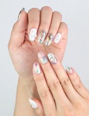 Close-up of Mermaid Sparkle short oval nails by Naillover, with gold foil and iridescent purple accents.