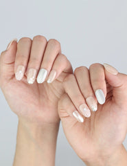 Elegant short oval-shaped nails in champagne tones with silver glitter by Naillover.