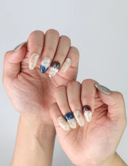 Hand posed with Oceanic Essence press on nails, showing fluid marble patterns and stylish ocean-inspired nail art.