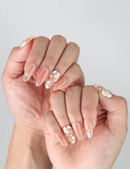 Peachy Glow handmade press on nails shown on hand with relaxed pose, highlighting elegant floral design