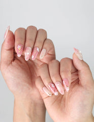 Side angle of fingers with Sakura press on nails by Naillover, capturing the raised flower detail and glossy pink background.