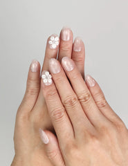 Model wearing Naillover Scarlet Gleam Singapore press on nails with pastel pink 3D flowers and rhinestones.