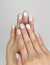 Model wearing Naillover Silver Skies handmade Singapore press on nails with silver star accents.