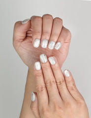 Close-up of Naillover Silver Skies Singapore press on nails showing sparkling white base and celestial star motifs.