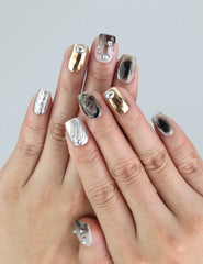 Model hand with Naillover Smoky Metal Rush nails — smoky gray press on nails with chrome details and marble swirls, handmade in Singapore.