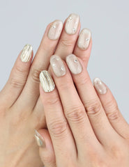 Wearing Naillover Starlet Shine press on nails—nude base with gold thread details for a classic minimalist look.