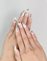 Model wearing Subtle Knots handmade Singapore press on nails with beige base and metallic accents