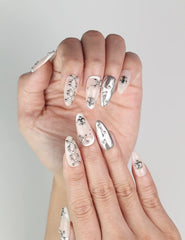 Close-up of Subtle Knots Singapore press on nails by Naillover showing metallic details on a beige background