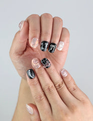 Model wearing Naillover Sweet Goth Singapore press on nails—handmade black and white set with shimmering silver touches.