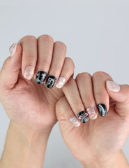 Naillover Sweet Goth press on nails styled on fingers—chic black and white palette with metallic details, perfect for edgy fashion looks.