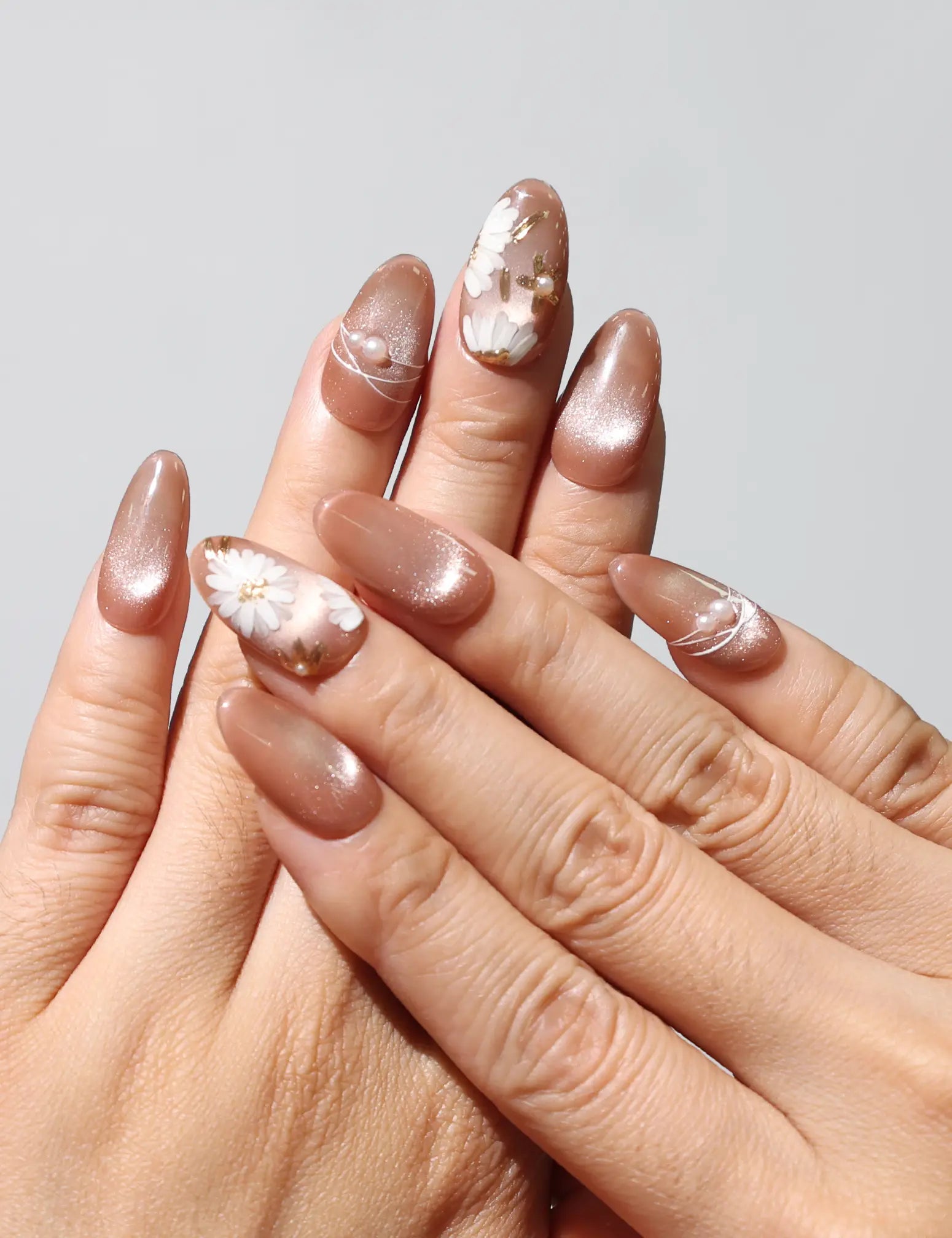 Wearing Tangerine Daisy Shine earthy tangerine handmade press on nails with white daisies and gold shimmer by Naillover Singapore.