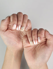 Elegant hand pose featuring Warm Petal handmade press on nails in Singapore pink-to-white ombre design with rhinestones
