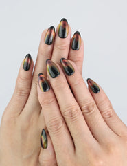 Close-up hand model wearing Noir Fade Tips black cat eye press-on nails with French fade from naillover Singapore collection.