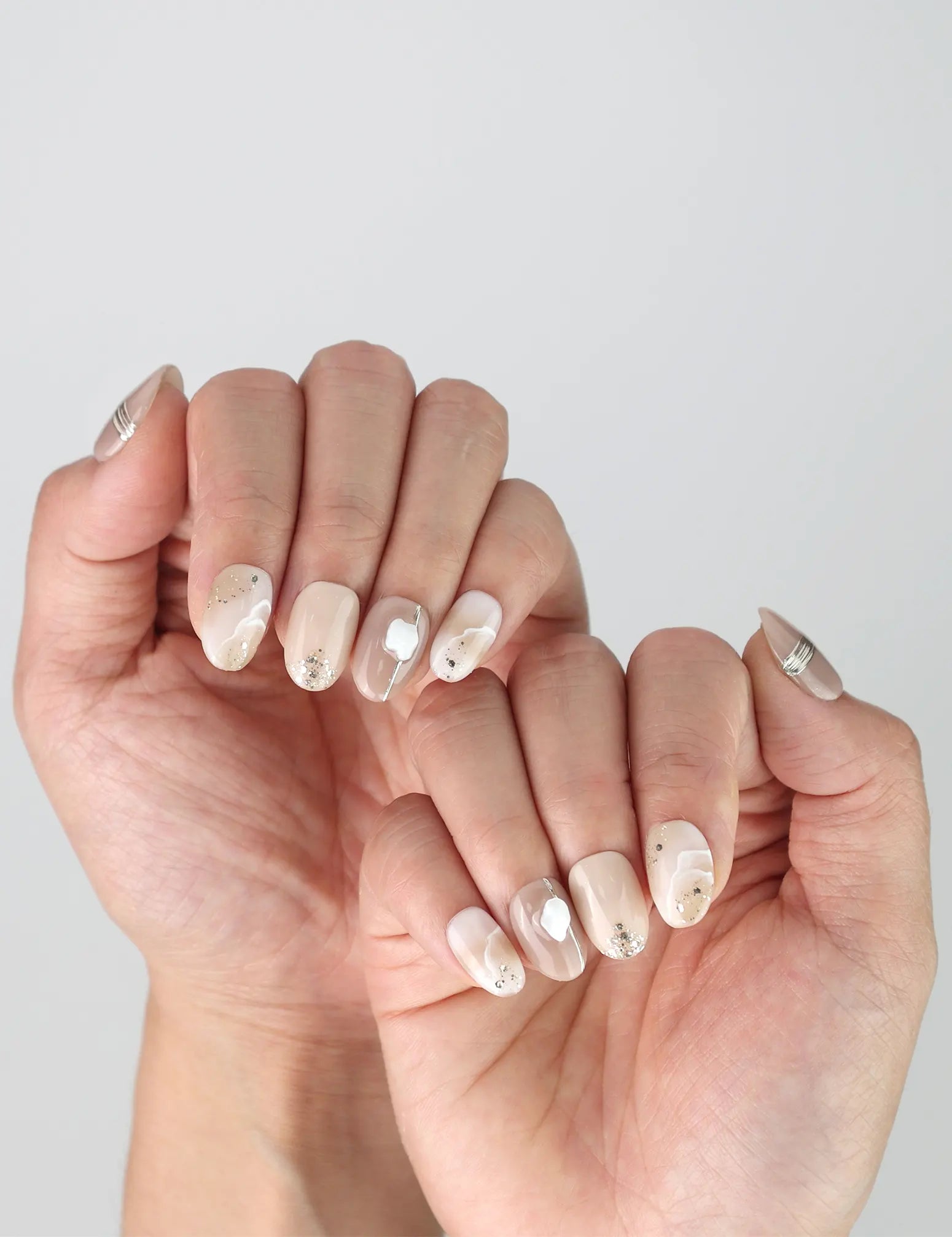 Side view of minimalist nude press-on nails featuring soft gold details, ideal for daily elegance