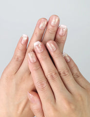 Hand gesture showing short peach pink press on nails with elegant gold lines and soft glitter, handmade in Singapore by Naillover