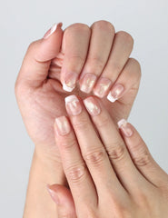 Close-up of Naillover’s Singapore handmade nails in peach tones with fine gold striping and a touch of shimmer