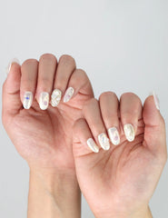 Side view of short oval nails with elegant rhinestone detailing and lustrous pearl accents