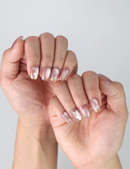 Side view of short pink square nails with 3D floral art, glossy finish, and tiny golden details