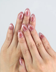 Model wearing Naillover Rosy French Glow pink almond press on nails with soft cat eye gradient.