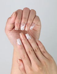 Close-up of Naillover’s handmade pink nails in square shape featuring sparkling gold glitter and elegant fine lines