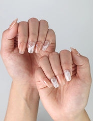 Side view of short pink square nails with delicate gold striping and shimmer for a classy manicure look