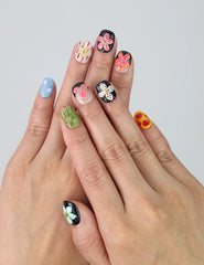 Hand showcasing squoval press on nails in black and nude with detailed 3D pink flower art by Naillover