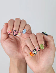 Elegant squoval nails with contrasting black and nude tones, highlighted by raised pink flower nail art