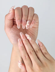 Close-up of Naillover’s handmade press-on nails featuring soft pink tones, 3D sculpted flowers, and glossy pearl décor