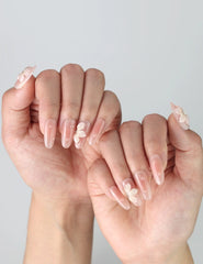 Side view of pink oval nails with dimensional flower art and lustrous pearl embellishments