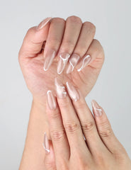 Close-up of Naillover’s handmade taupe nails featuring fluid white lines and shiny gold foil detailing