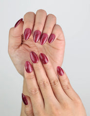 Close-up of handmade Wine Illusion press on nails in deep red with magnetic glow, from Naillover Singapore.